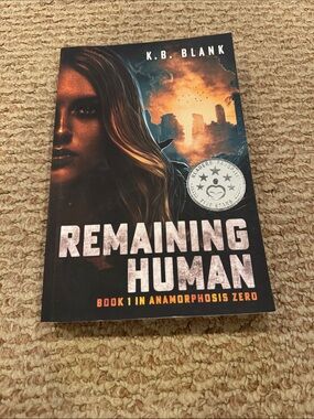 Remaining Human by K.B. Blank - Black & Orange Paperback